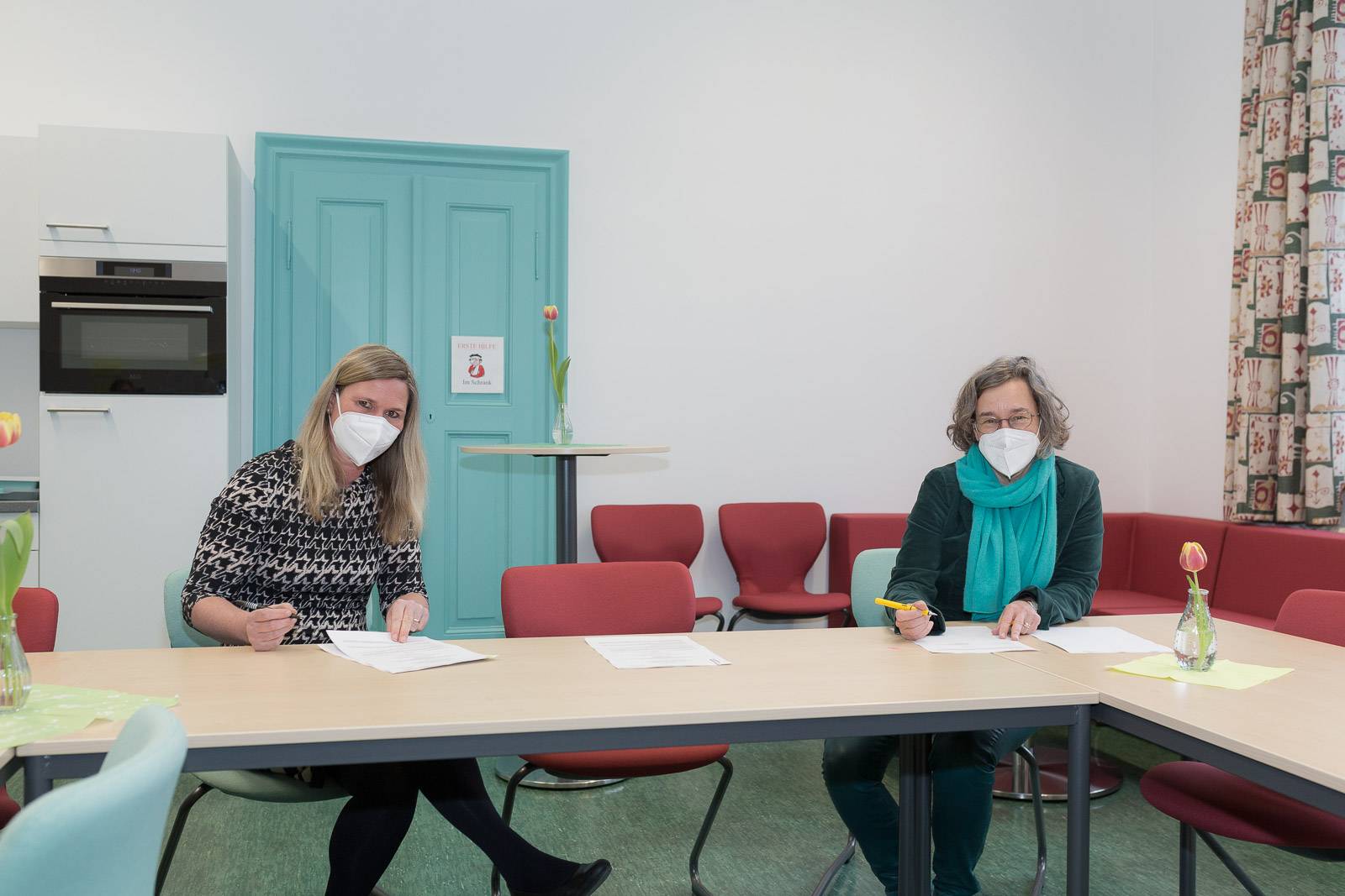 Daniela Flaschke, Rektorin der Grundschule Augsburg Vor dem Roten Tor (links), und Prof. Dr.-Ing. Elisabeth Krön, Vizepräsidentin für Weiterbildung und Wissenstransfer der Hochschule Augsburg unterzeichnen die Koopertionsvereinbarung für das Transferprojekt HSA_teach.