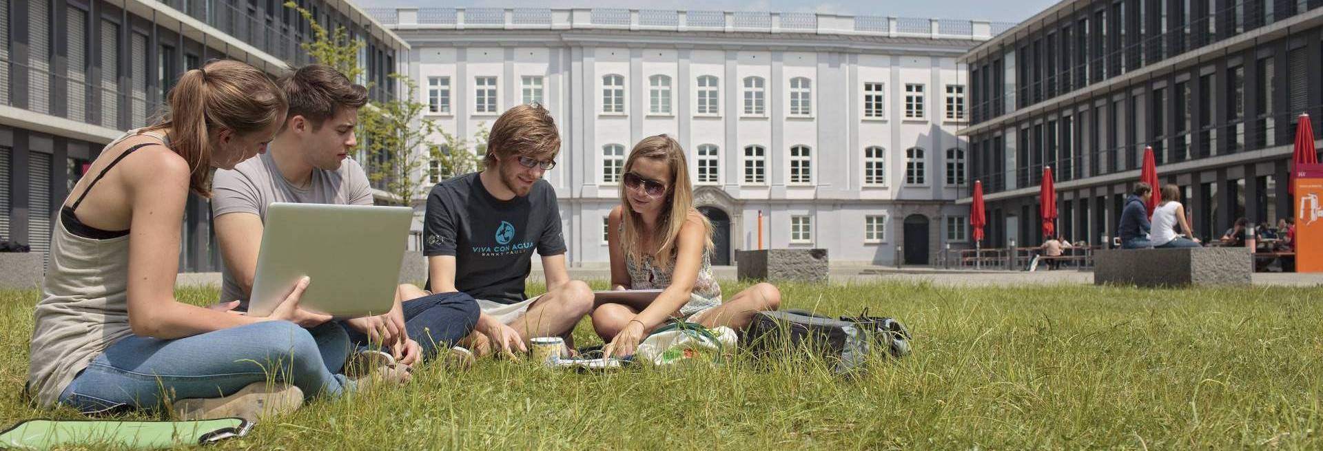 Studierende auf der Wiese im KLM-Innenhof. Foto: Florian Hammerich, www.altrofoto.de