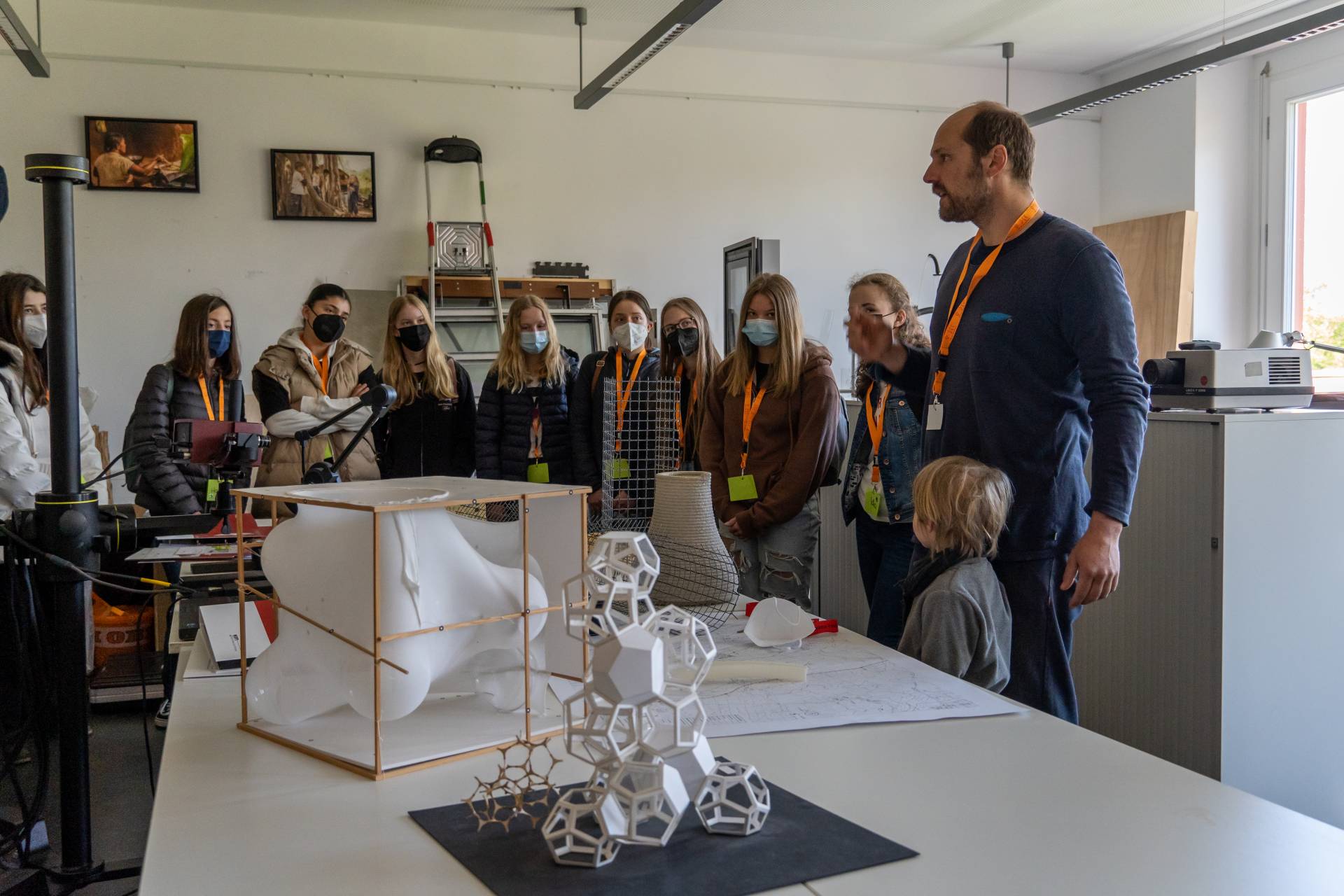 Schülerinnen betrachten Modelle aus verschiedenen Materialien