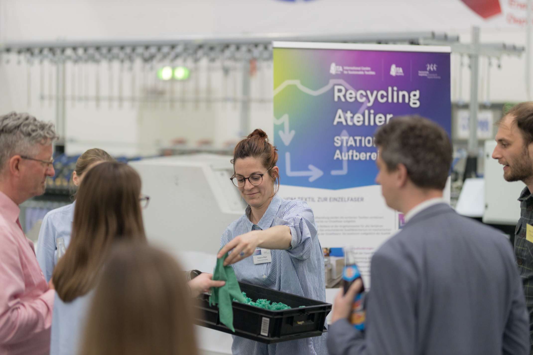 Frau verteilt Stoffproben während eines Workshops im ELLSI