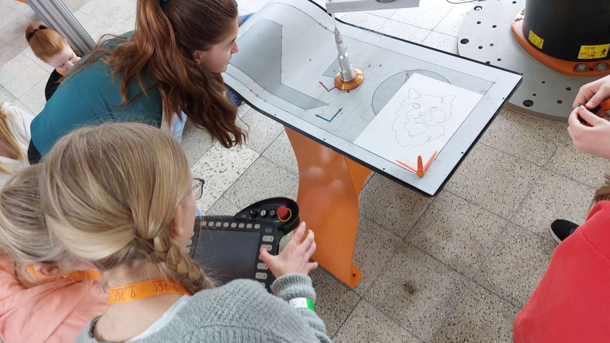 Die Schülerinnen übernehmen die Steuerung des Industrie-Roboters.