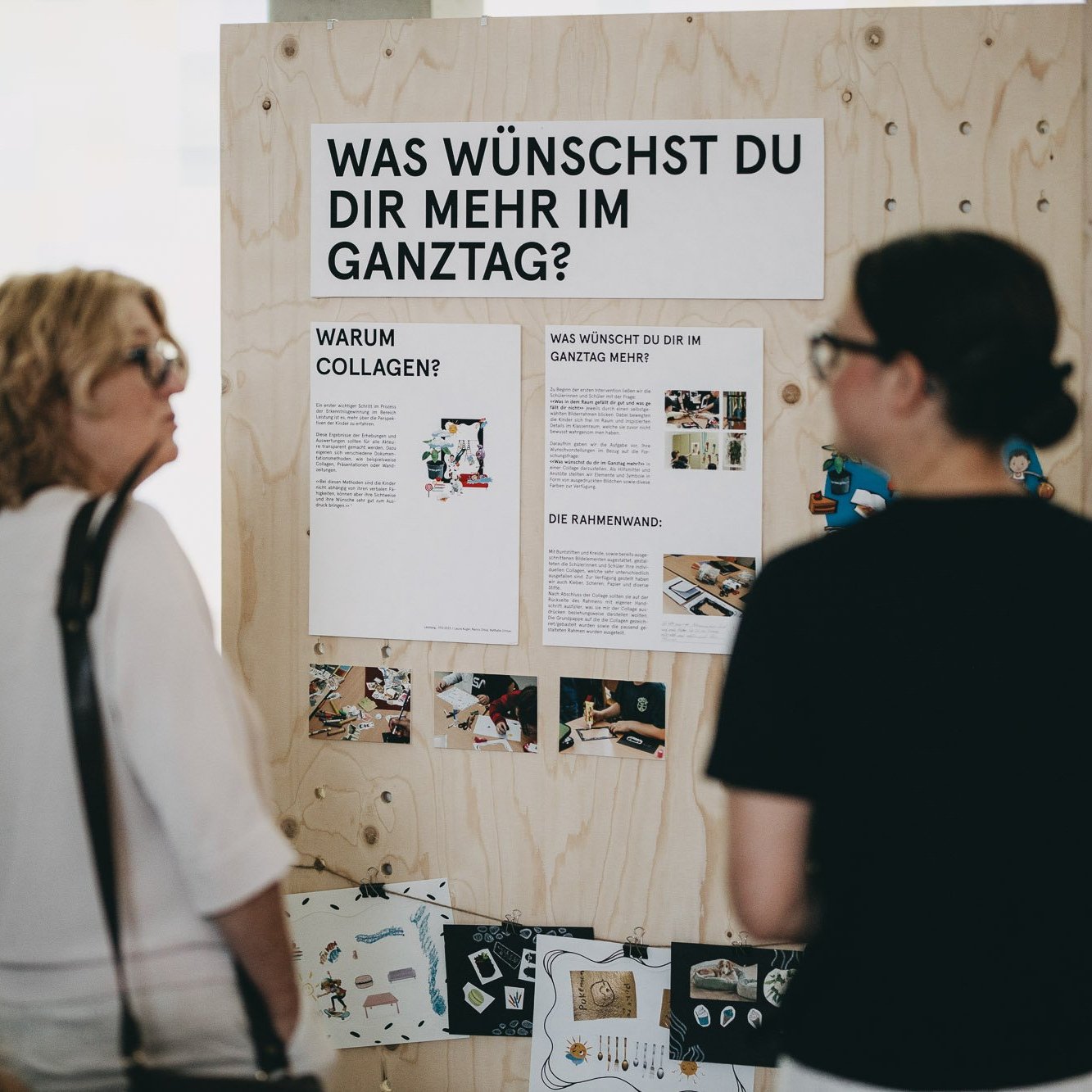 Mehrere Besucher:innen betrachten die Ausstellung "Was braucht der Ganztag"?