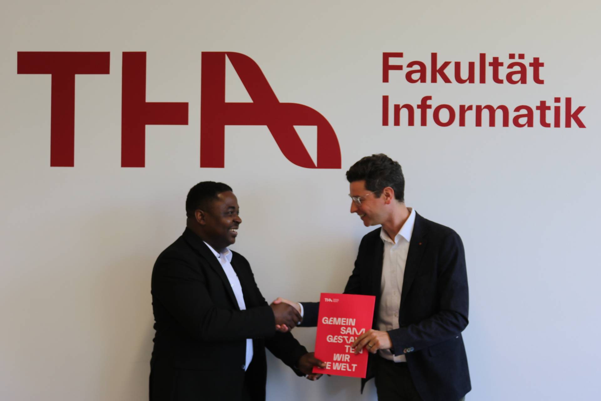 Professor Dr. Zimmermann congratulates Adesina Akinkunmi on passing his bachelor's degree in International Information Systems.