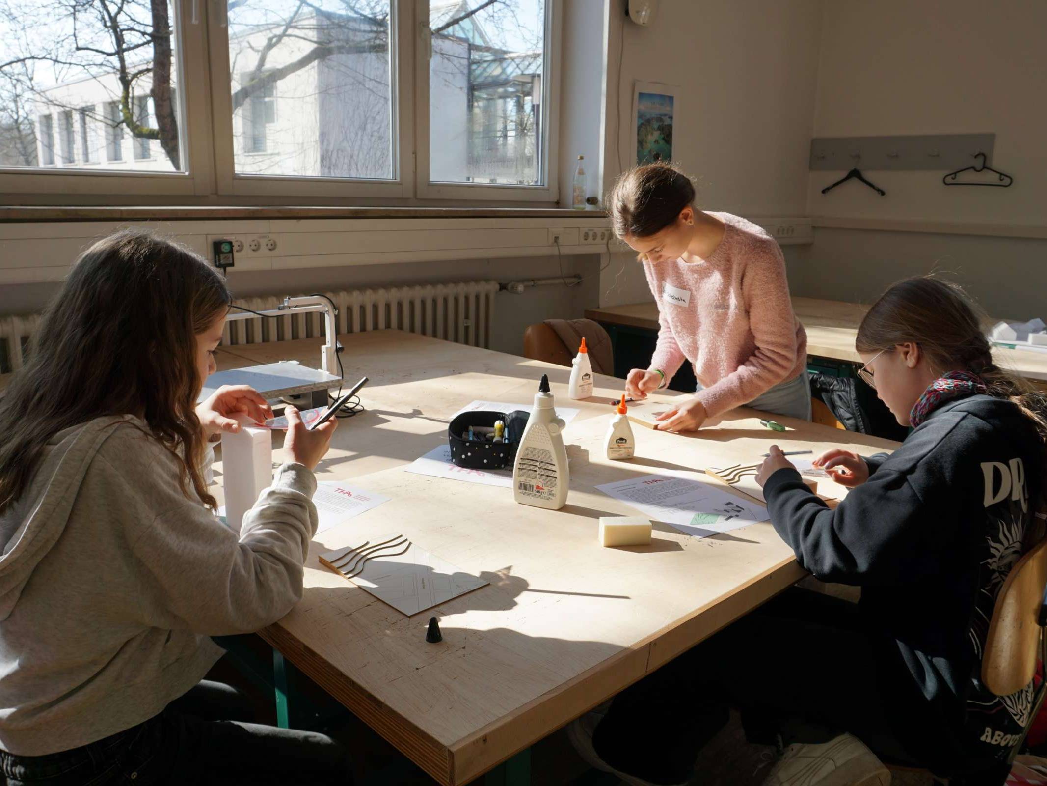 Schülerinnen bauen an ihren Modellen in der Holzwerkstatt