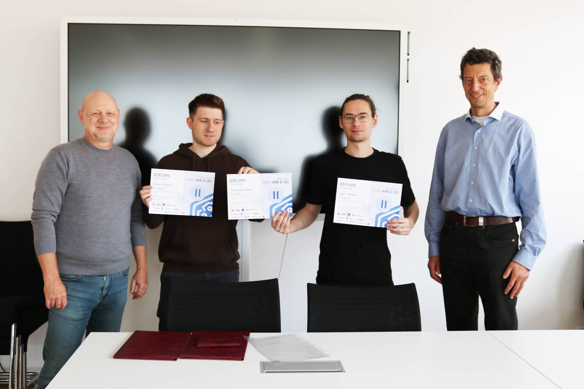 Urkundenübergabe an zwei Studenten.