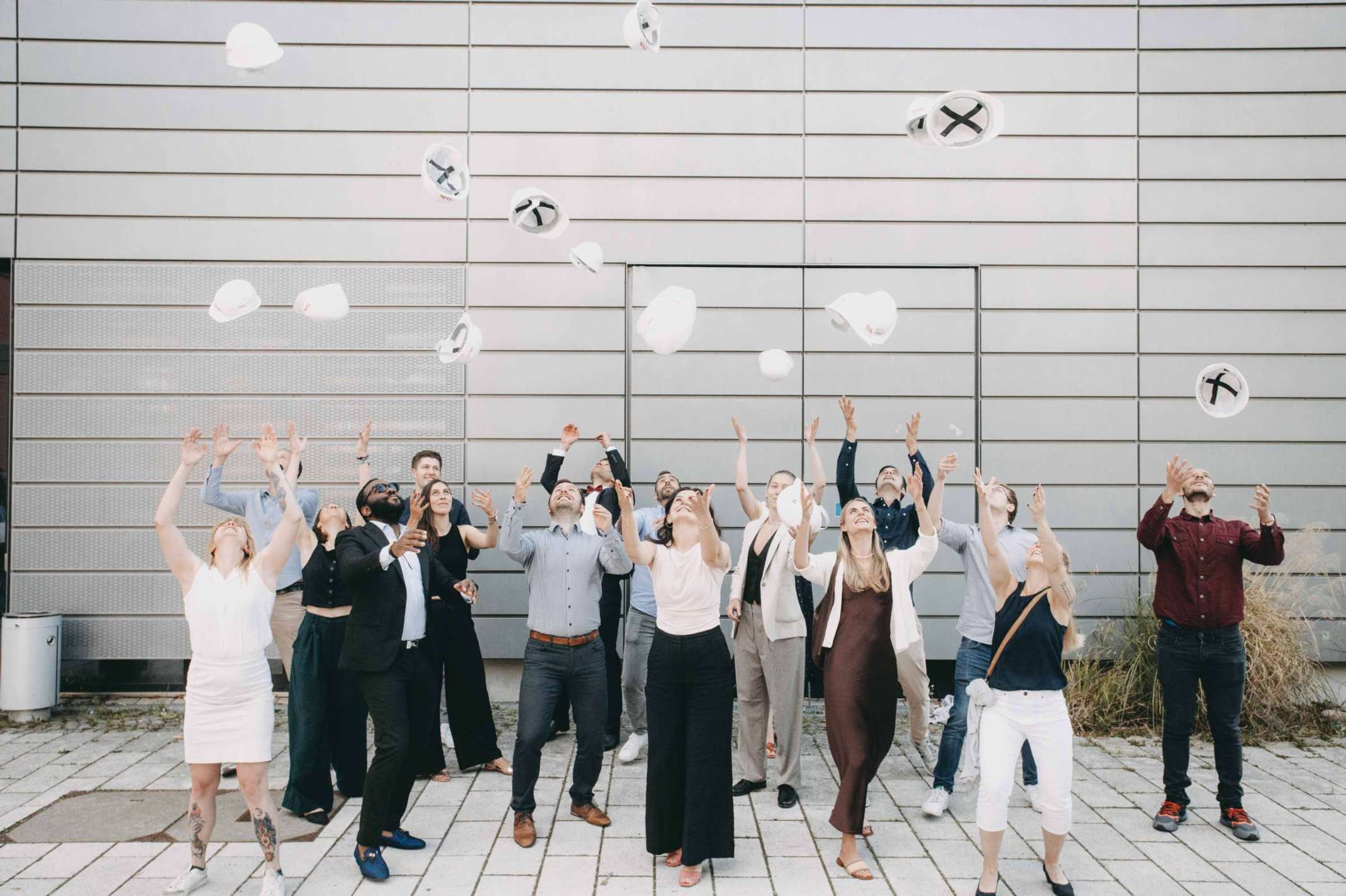 9_Frisch gebackene Master Projektmanagement Bau werfen die traditionellen Masterhelme in die Luft. Foto: Matthias Leo