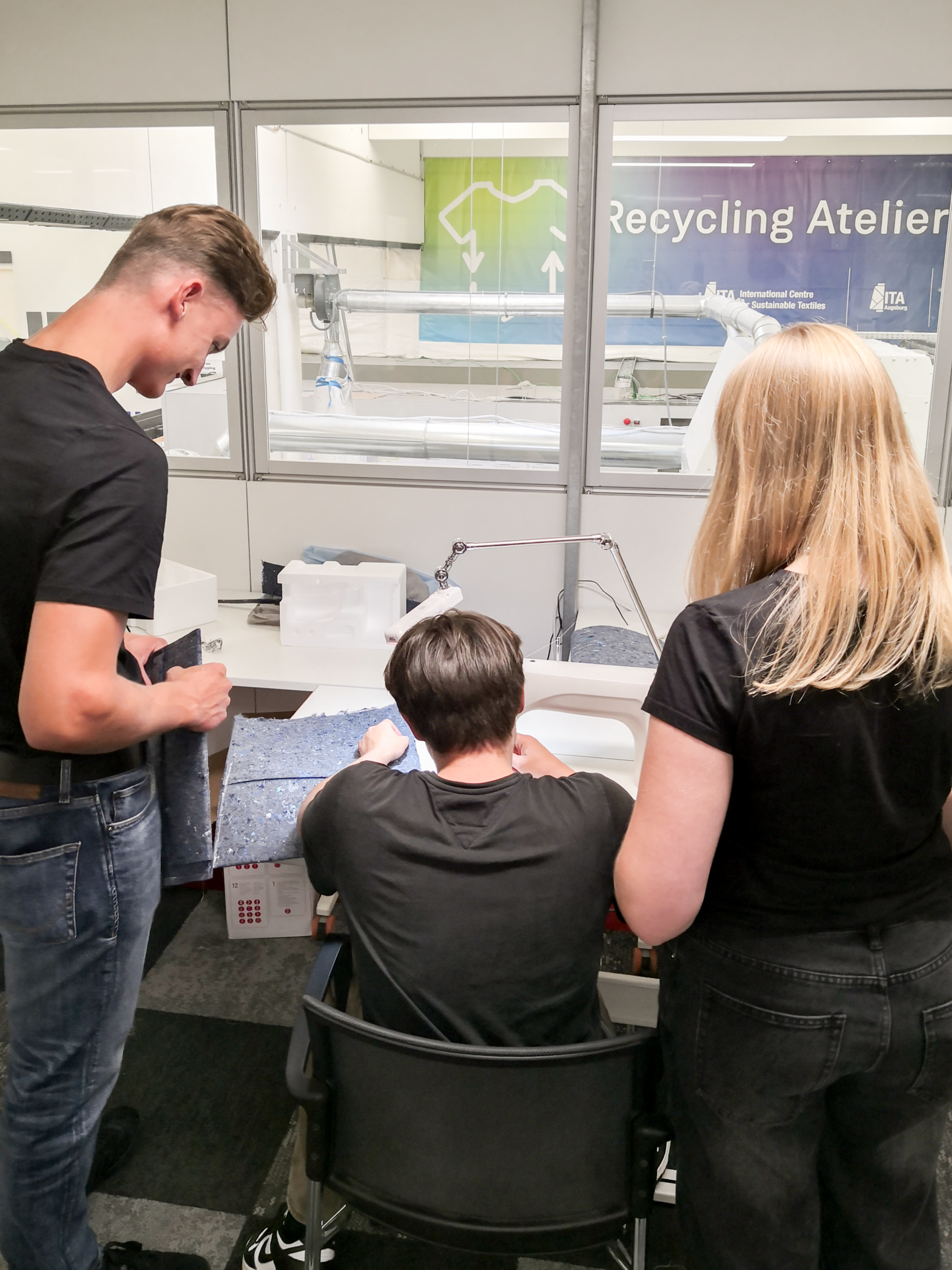 Studierende nähen Laptoptaschen im Recycling Atelier