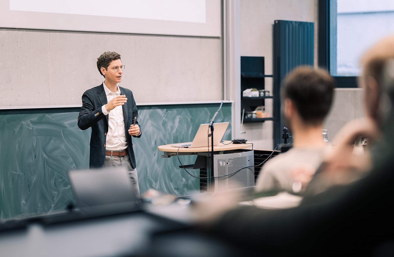 Prof. Zimmermann im Hörsaal vor Studierenden