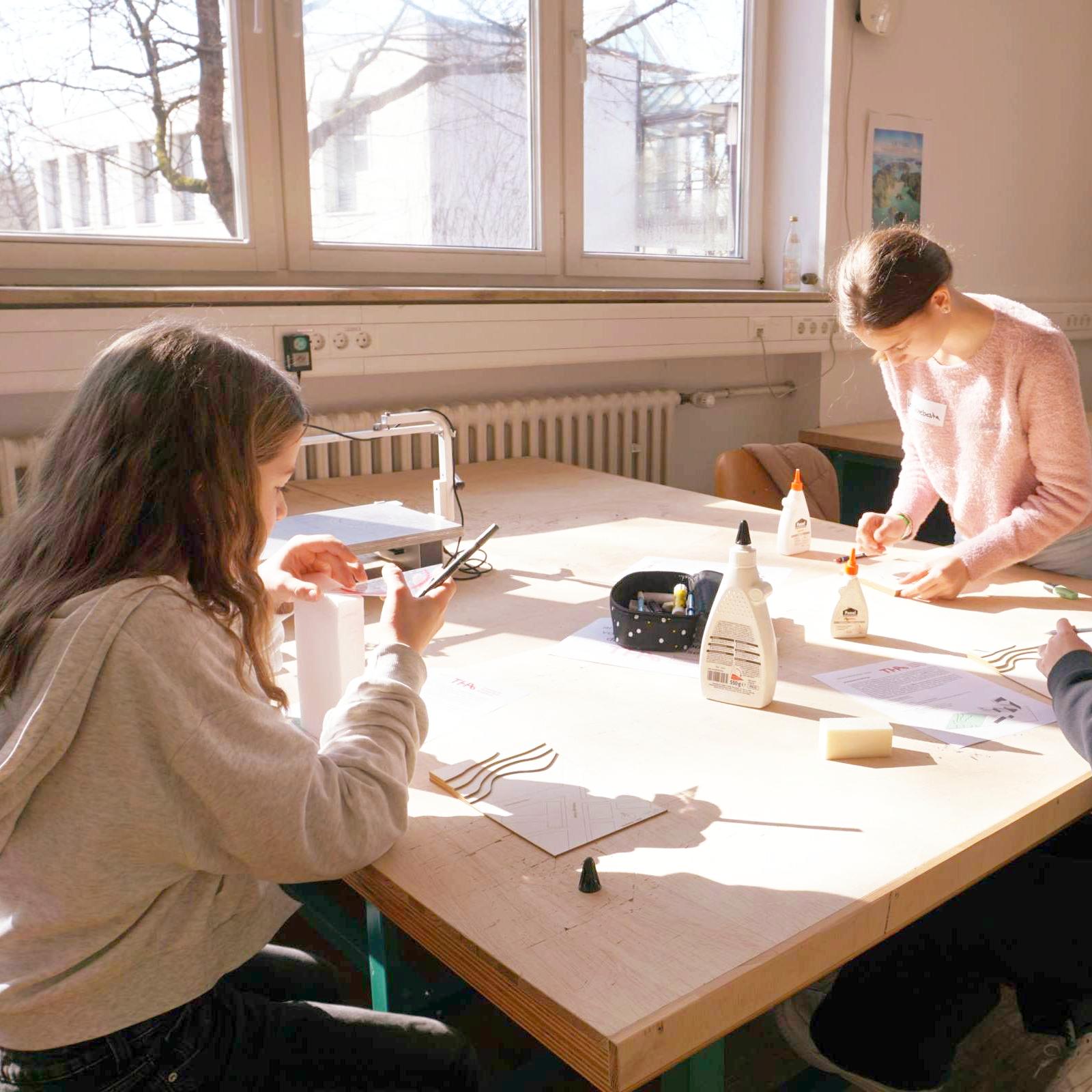 Schülerinnen bauen an ihren Modellen in der Holzwerkstatt