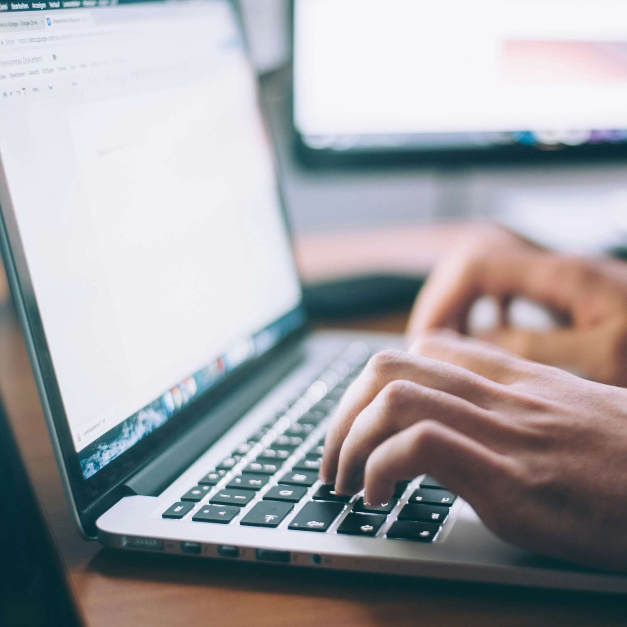 Person tippt auf Laptop