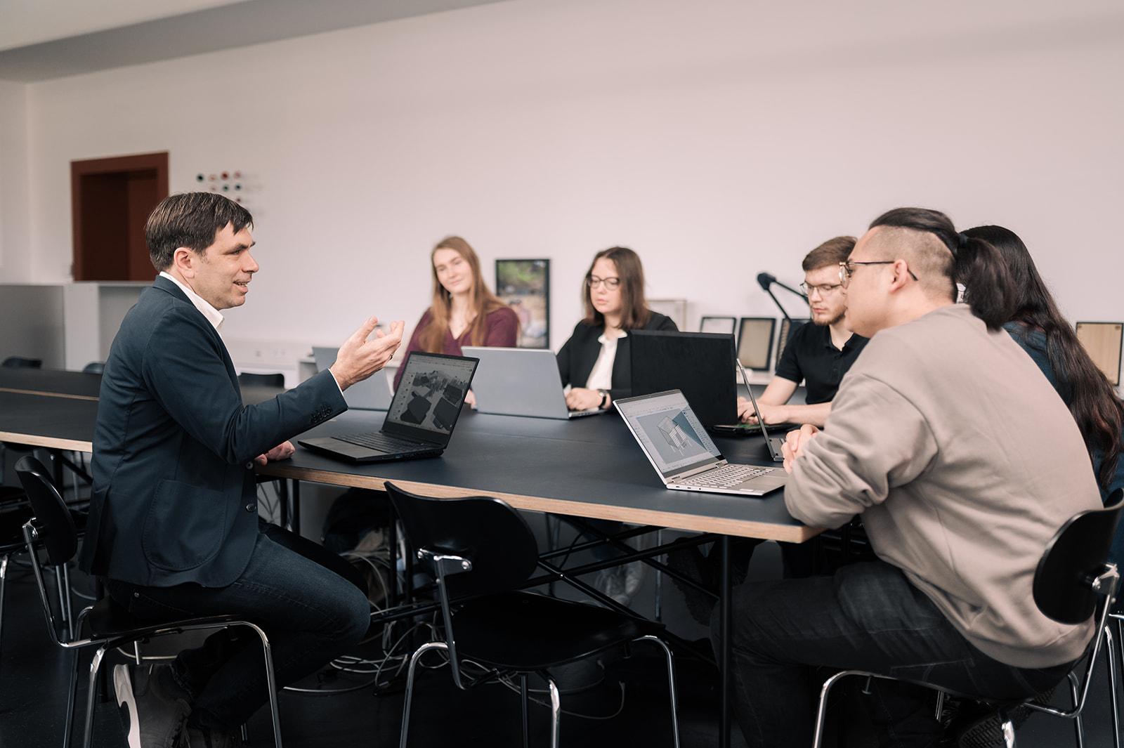 Professor in Besprechung mit Studierenden