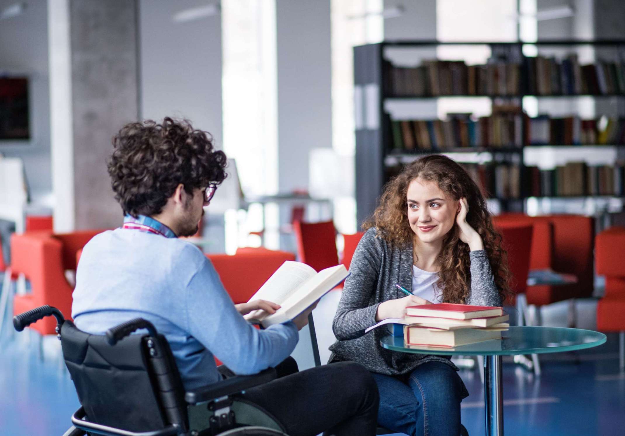 Studierende mit sichtbarer und unsichtbarer Behinderung in einer Bibliothek