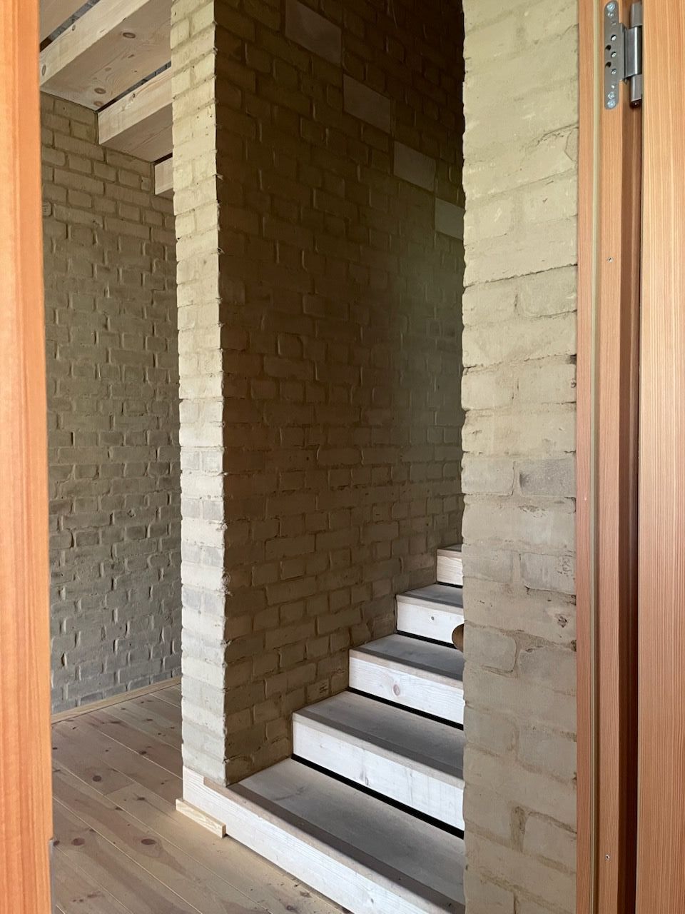 Treppenaufgang aus Sichtbeton, Holz an den Wänden.