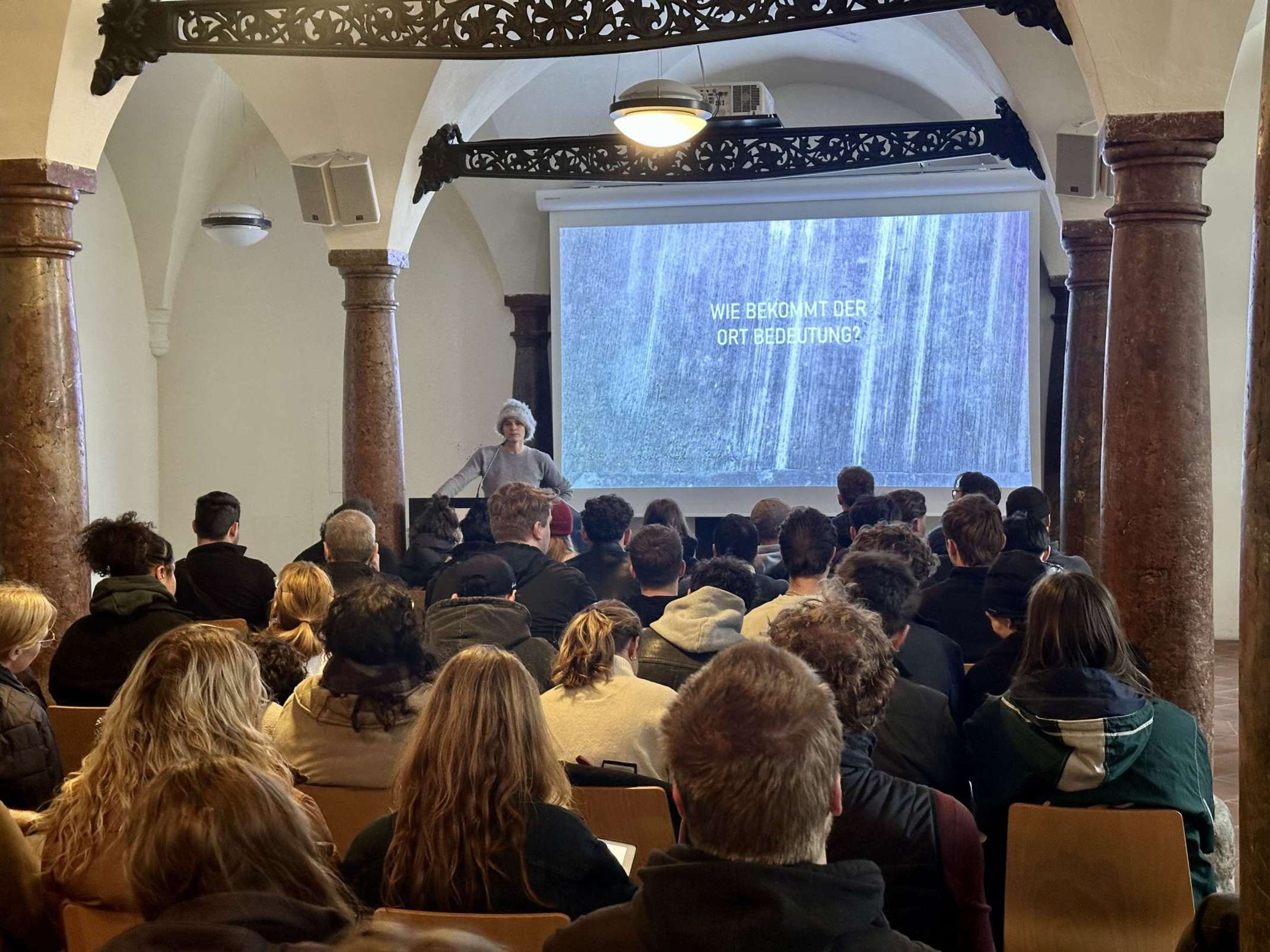 Dr. Judith Sandmeier berichtet in der Säulenhalle der Alten Münze vor 70 interessierten Studierenden über innovative Ansätze in der Denkmalpflege (Foto: Christian Bauriedel)