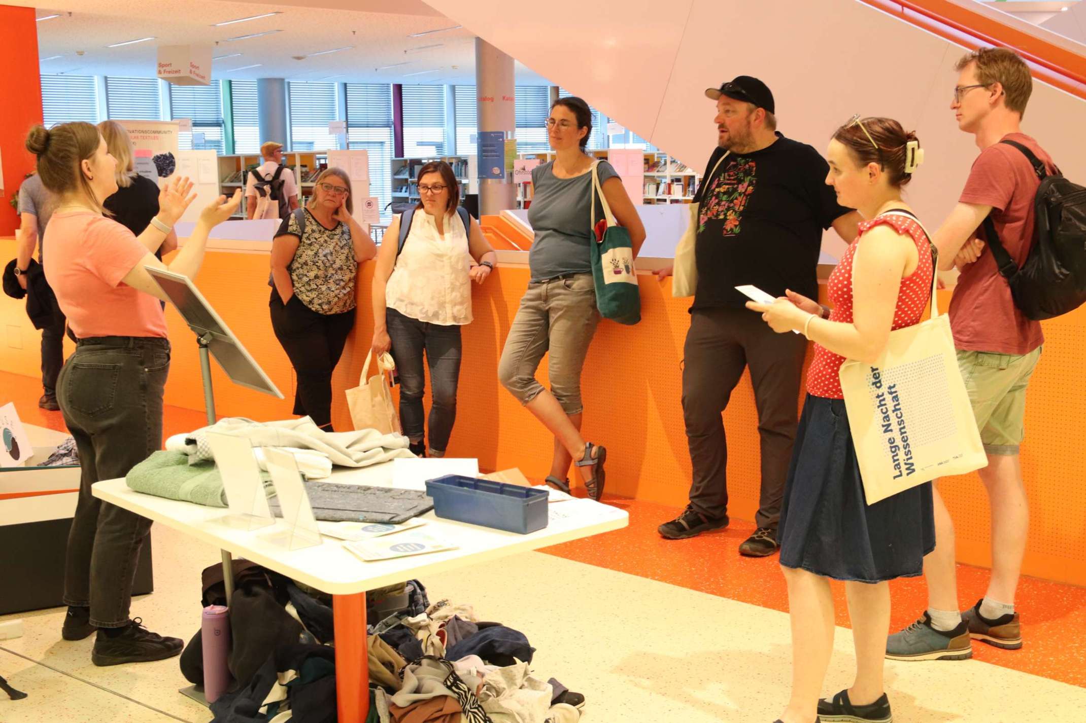 Projektmitarbeiterin Svenja Jahn (NuCollect, ITA Augsburg) erläutert den Besucherinnen und Besuchern den NuCollect "Textilcheck" anschaulich an Kleidungsstücken. Projektmitarbeiterin Svenja Jahn (NuCollect, ITA Augsburg) erläutert den Besucherinnen und Besuchern den NuCollect "Textilcheck" anschaulich an Kleidungsstücken.
